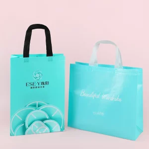 Custom nonwoven bags for clothing packaging in turquoise blue with handles