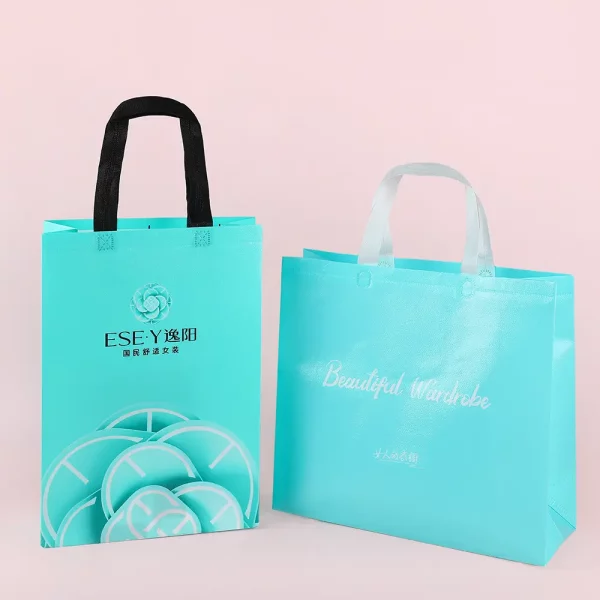 Custom nonwoven bags for clothing packaging in turquoise blue with handles