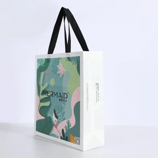 Side angle of nonwoven fashion clothing bag with black handles